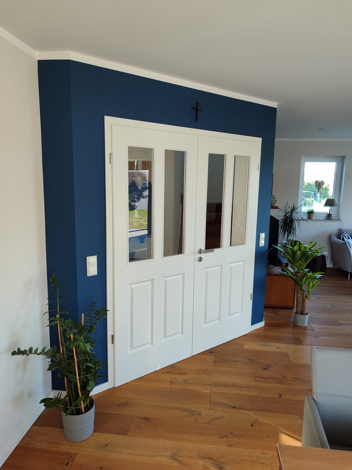 Blaue Akzentwand mit weißer Flügeltür